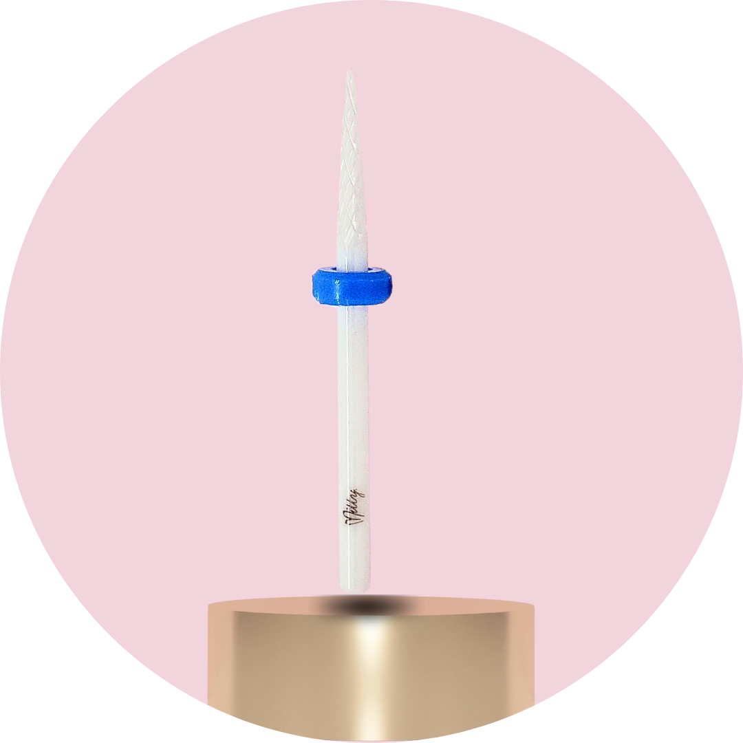Candle with a blue wick holder on a gold base against a pink background